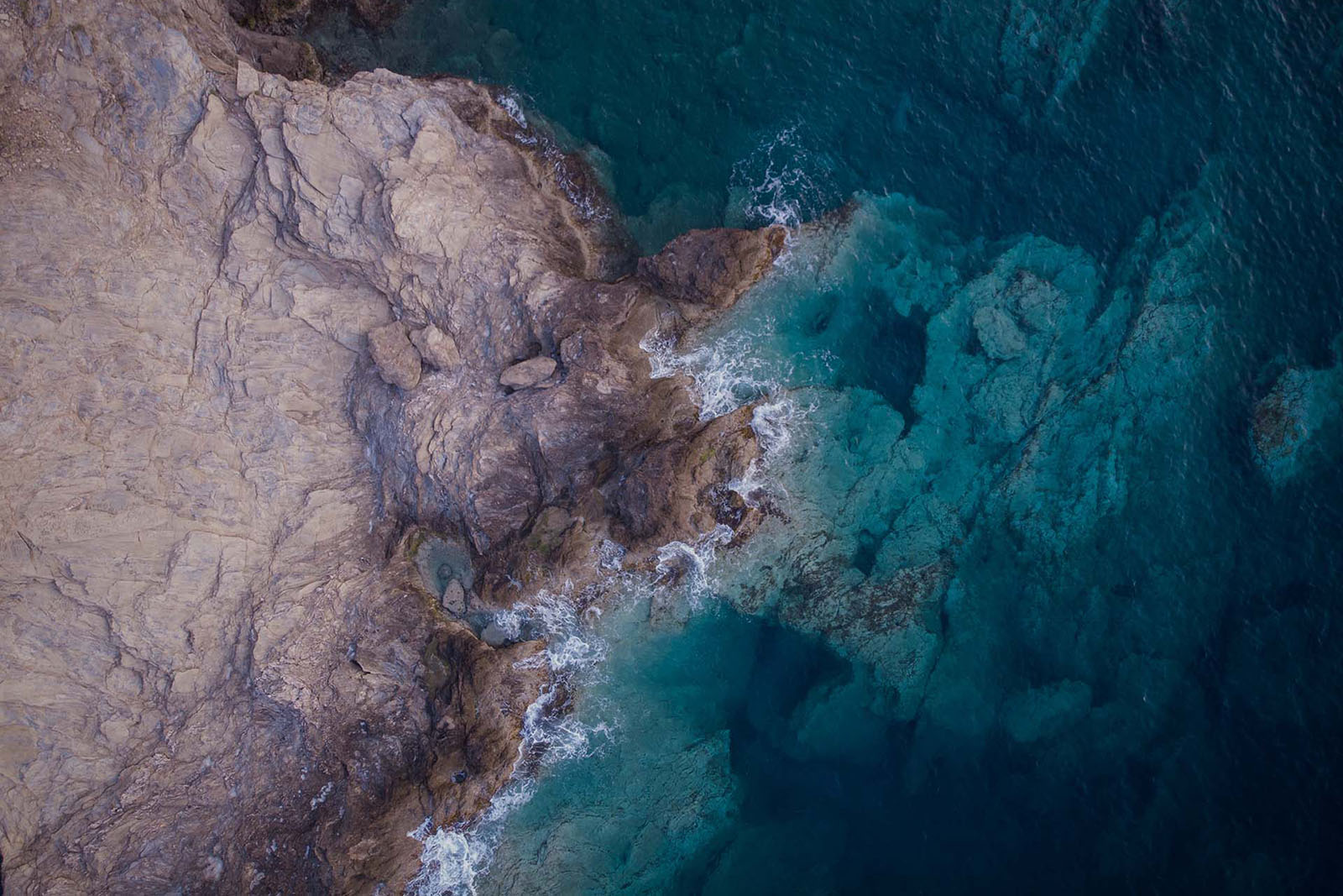 Aerial view of the rocky Cretan shoreline and clear turquoise water