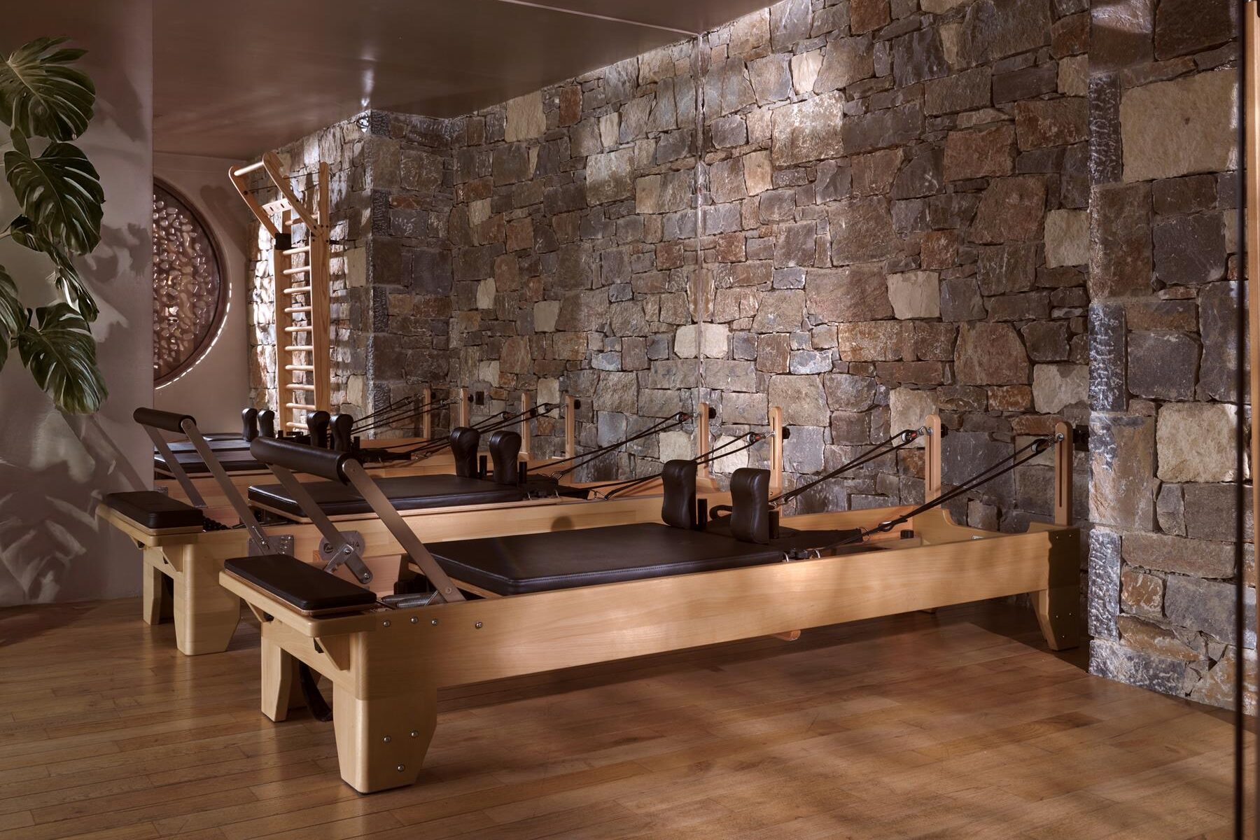 Wooden reformer beds in Acro’s stone-walled Pilates Studio
